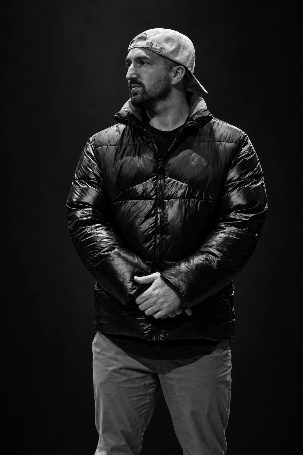 Black-and-white portrait of Zach in a puffer jacket and backwards cap
